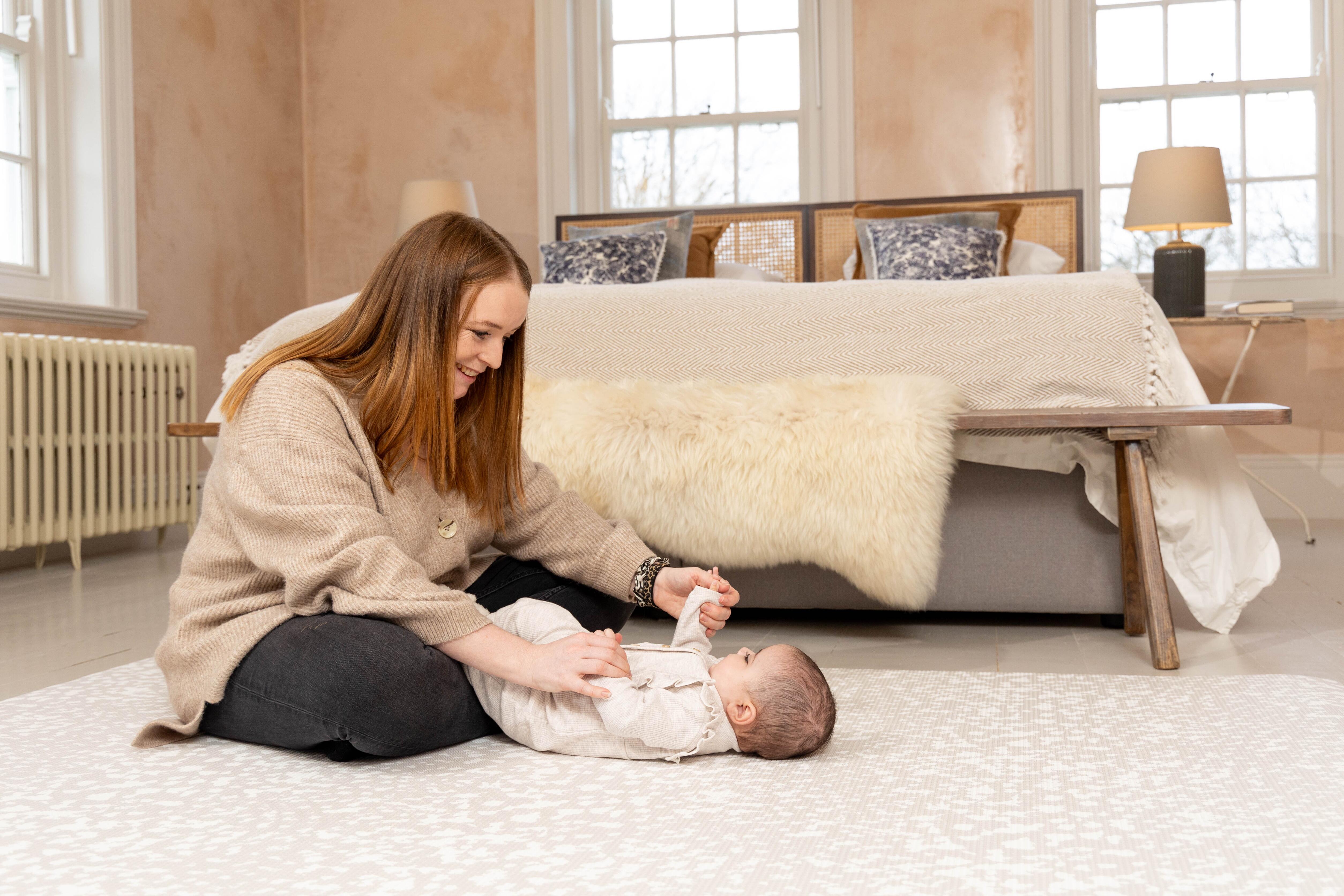 Lifestyle photo of Speckled Kisses Luxury Greige Playmat – reversible cushioned baby mat for calm neutral nurseries
