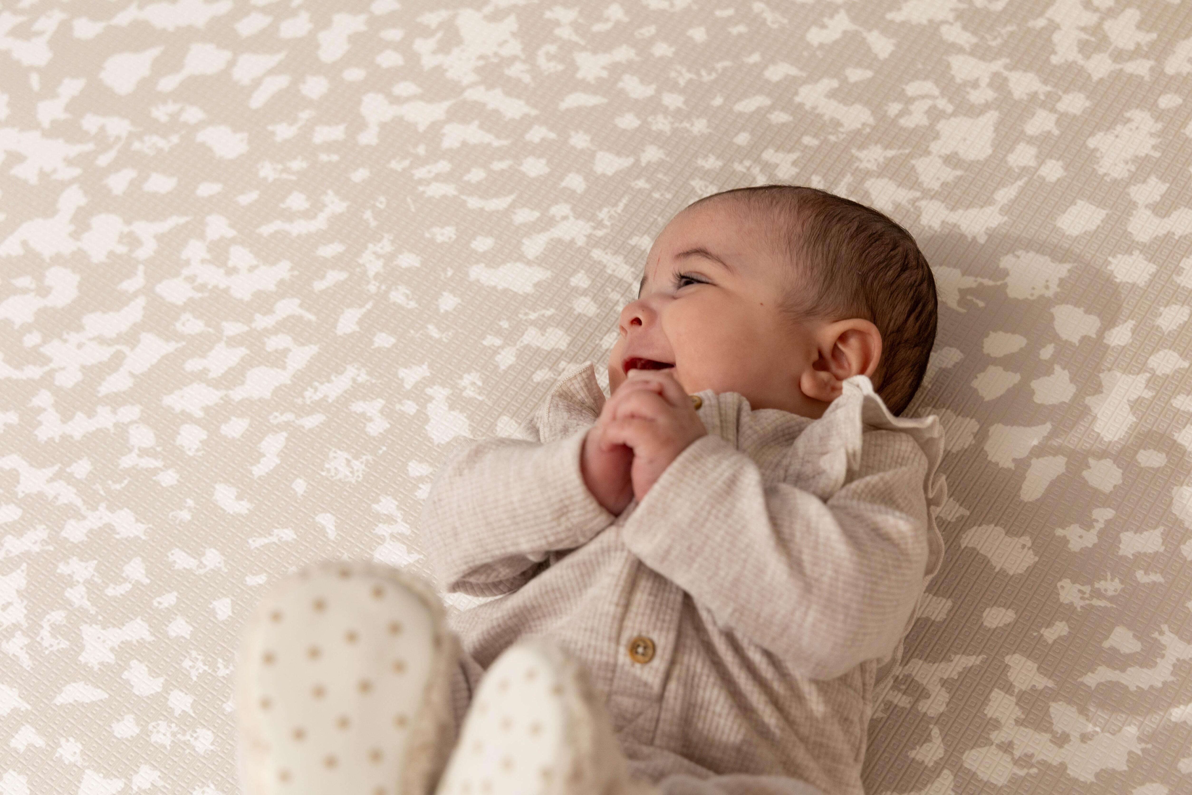 Close-up of Speckled Kisses Luxury Greige surface – wipe-clean non-PVC reversible baby playmat with soft matte finish