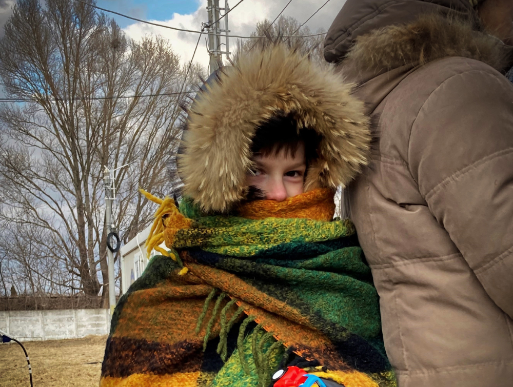 Child wearing a coat with hood up in Moldova.