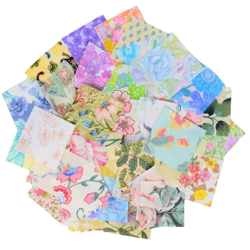 Flat lay of a selection of vintage floral fabric squares arranged in a rough circular shape on a white background