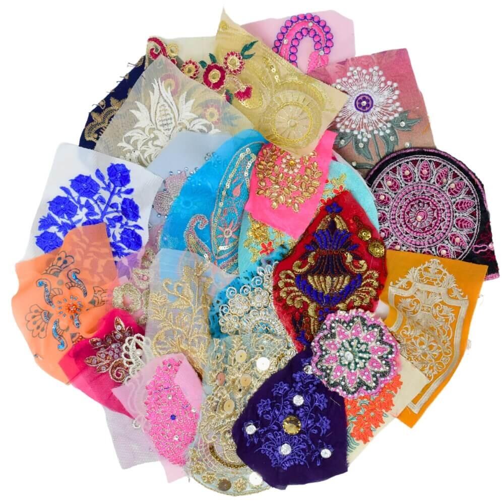 Flay lay of a selection of decorative and multicoloured Indian fabric motifs arranged in a circular shape on a white background