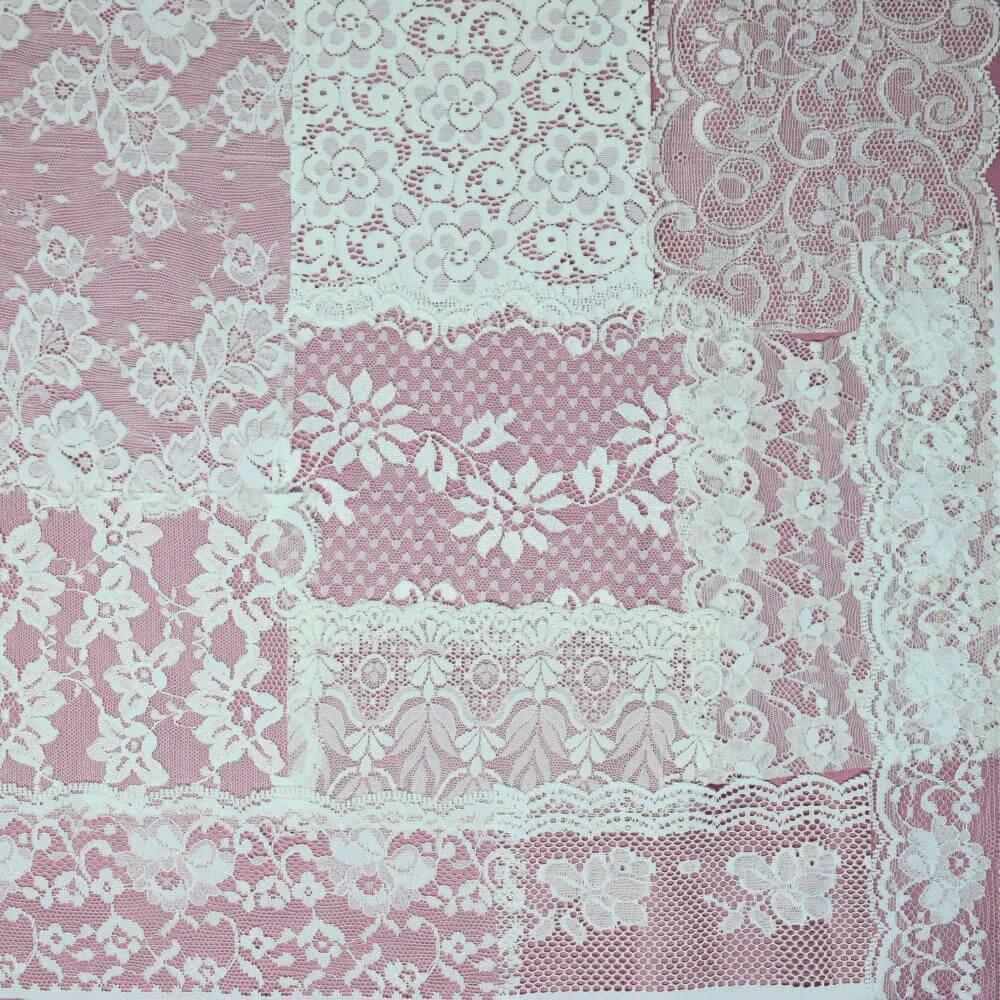 Flatlay of some pieces of white lace fabric and trim arranged in a square shape on a lilac background