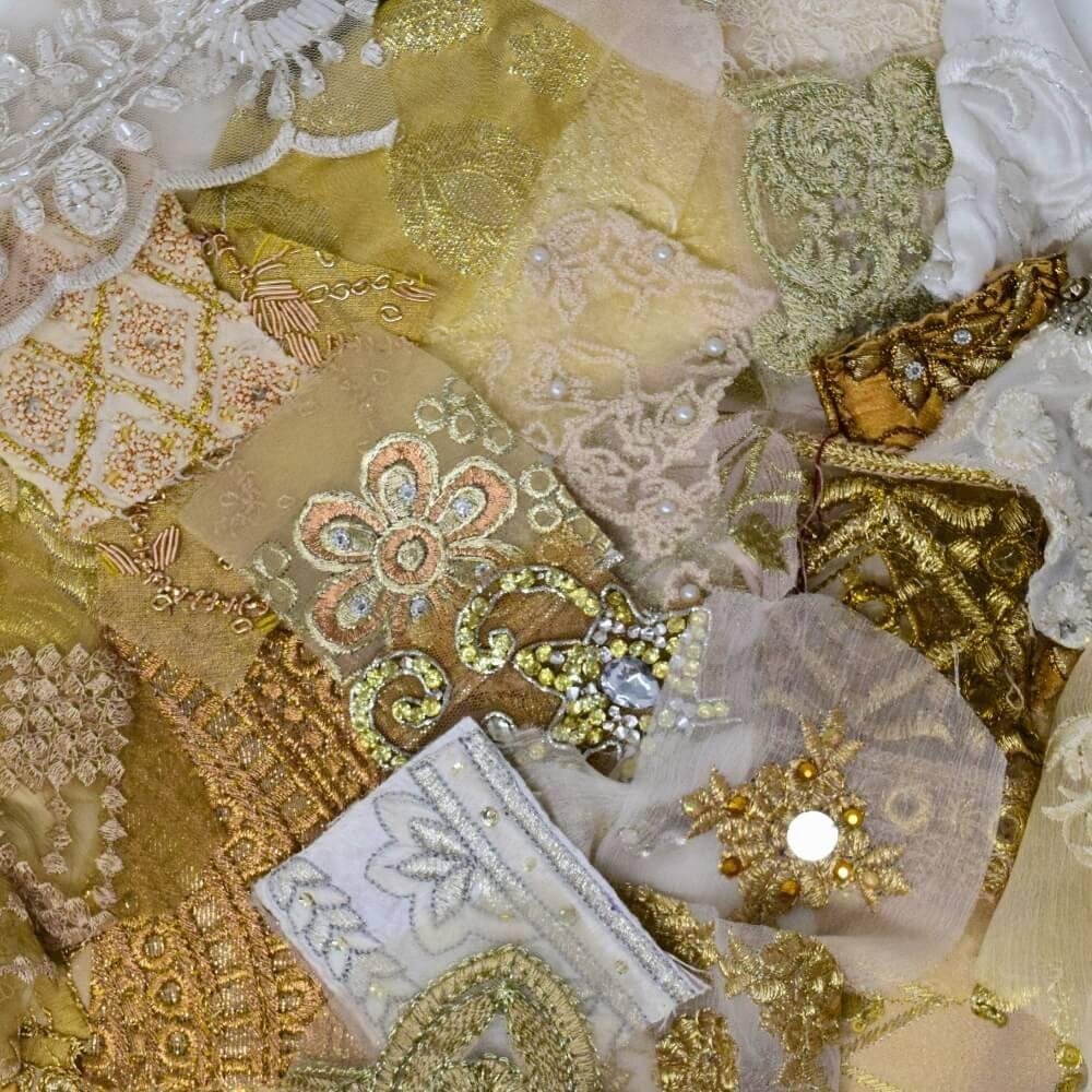 Flat lay of some very small pieces of embellished sari fabric scraps in a neutral colour mix