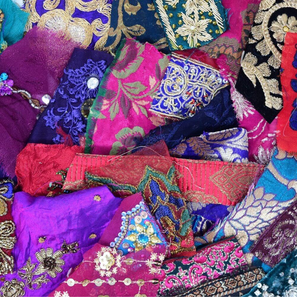 Close up detail of some embellished sari fabric scraps in a deep and opulent colour mix