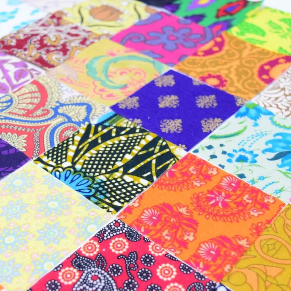 A diagonal shot of a flat lay selection of ethnic print fabric squares arranged in