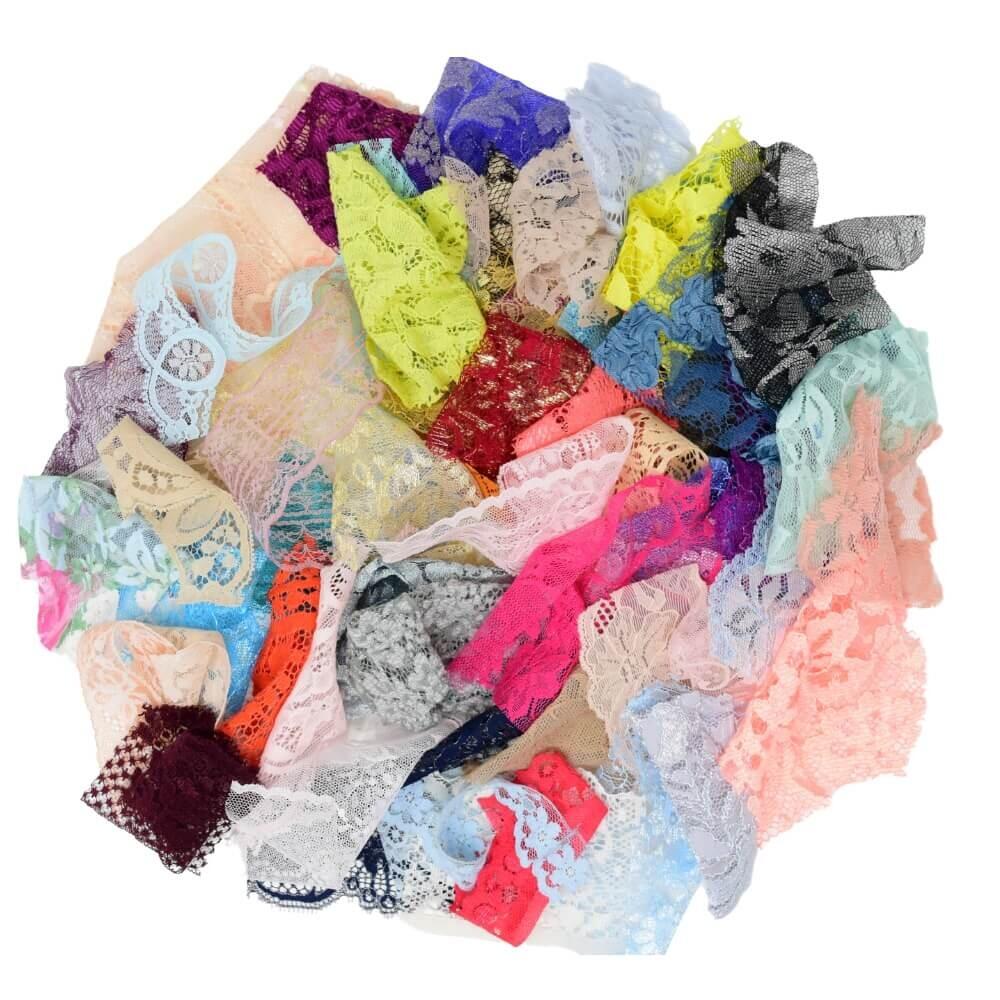 Flat lay of a selection of multicoloured lace craft fabric pieces arranged in a circular shape on a white background