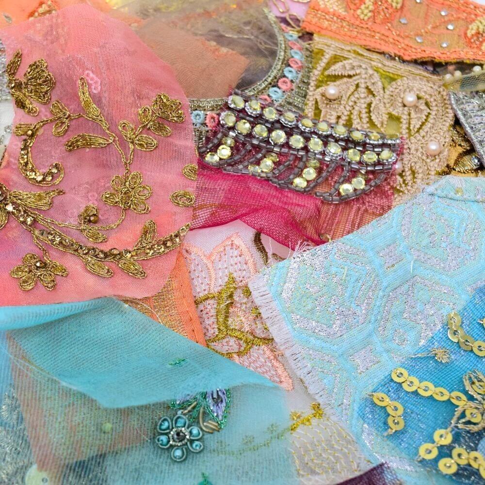 Close up detail of some embellished sari fabric scraps in a muted and pastel colour mix