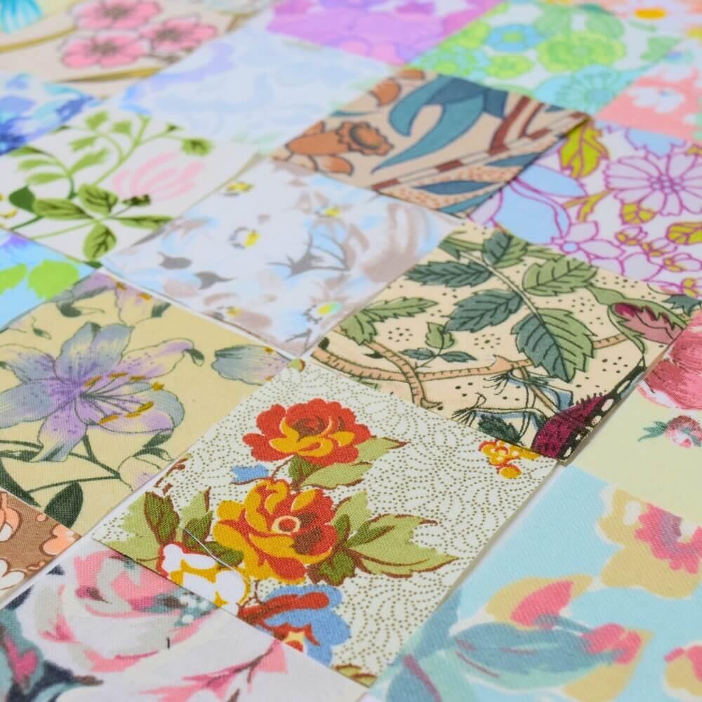 A diagonal shot of a flat lay selection of vintage floral fabric squares arranged in