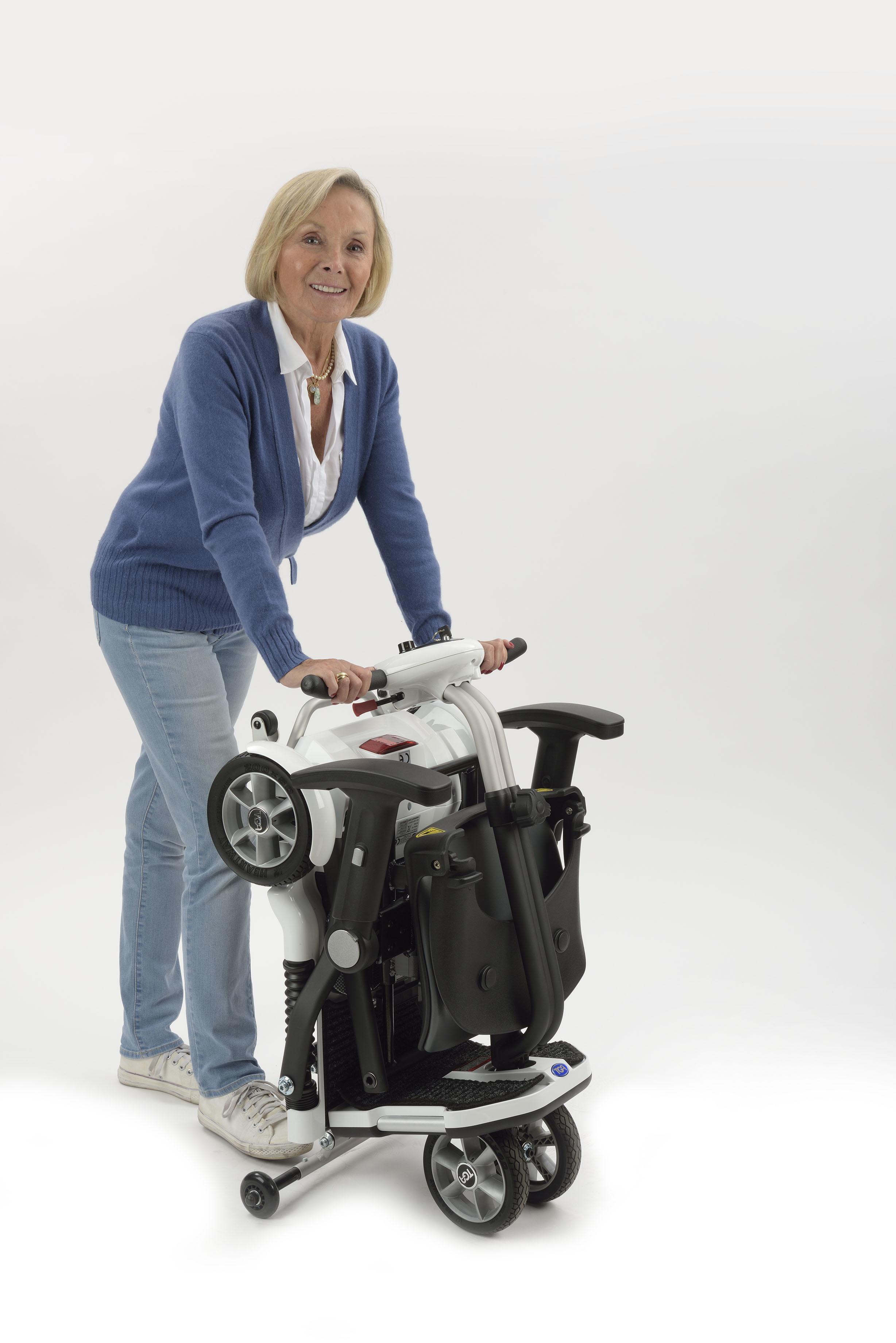 Lightweight TGA minimo mobility scooter being moved around by a lady in our kent showroom