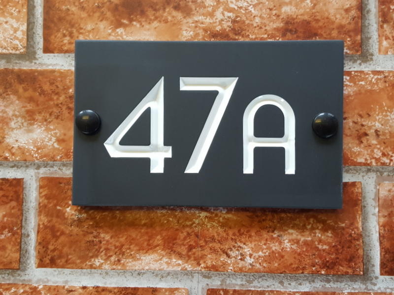 Slate house sign depicting number 47A with a white inlay