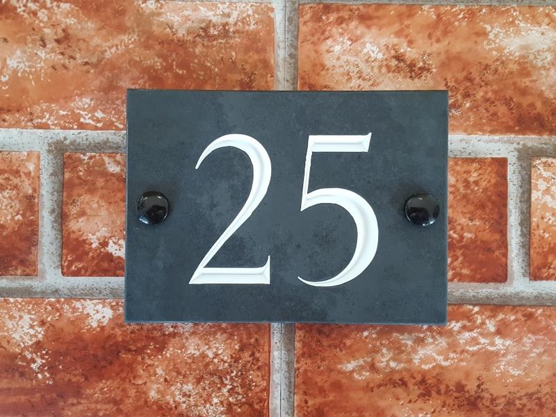 Slate house sign depicting number 25 with a white inlay