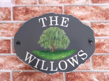 House sign depicting a willow tree and the house name The Willows