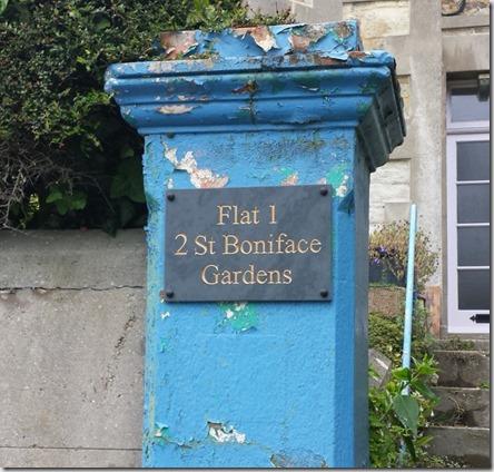 Image displaying slate house sign on a painted stone pillat that requires refurbishment