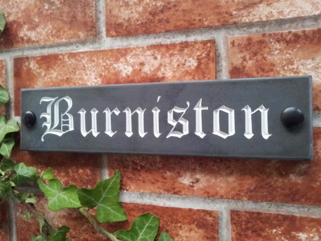 Slate sign displaying Burniston with white inlay
