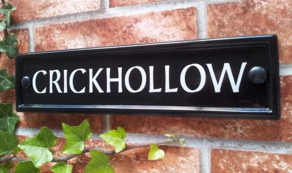 Black rectangular house name sign with Crickhollow