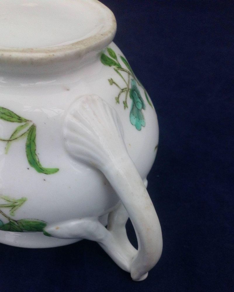 Antique low round porcelain creamer or milk jug made by John Rose of  Coalport Porcelain Works with transfer printed and hand coloured turquoise and green flowers pattern. Dates to circa 1820.