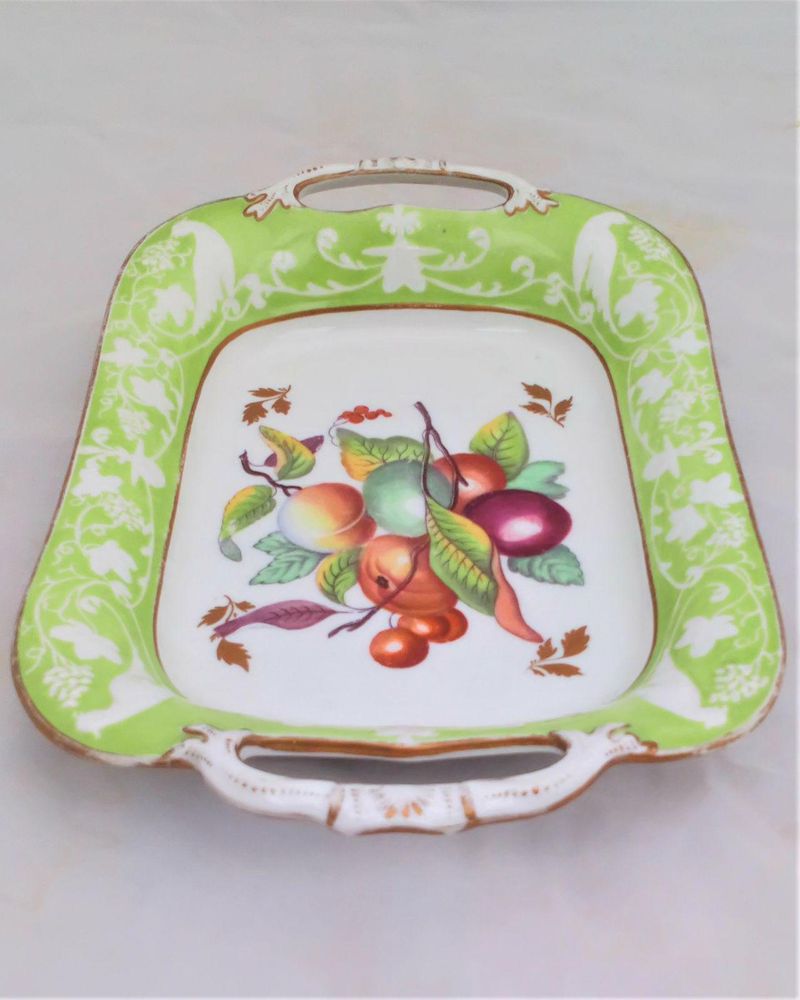 Antique New Hall Porcelain rectangular twin handled dessert dish with low relief rim of birds and fruiting vines on a light green ground. It has a central transfer printed and hand coloured fruit decoration , made in the Georgian period circa 1820 to 1831.
