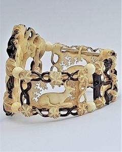 A superb antique hand carved deer antler elasticated panel bracelet with exquisite detail and brown enamel highlighting. The main panels are decorated with deer, the large one with a hart or stag and the sides with seated does. The bracelet dates from the middle of the 19th century in the Victorian period circa 1850. Probably carved in the Black Forest region.