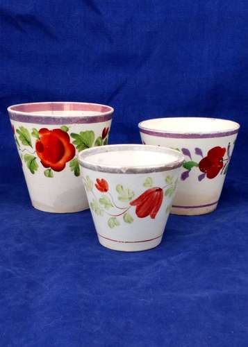 Three antique graduated pearlware and creamware pottery pink lustre ale beakers or cups with hand painted flowers circa 1820