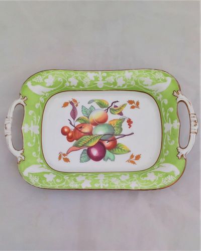 Antique New Hall Porcelain rectangular twin handled dessert dish with low relief rim of birds and fruiting vines on a light green ground. It has a central transfer printed and hand coloured fruit decoration , made in the Georgian period circa 1820 to 1831.