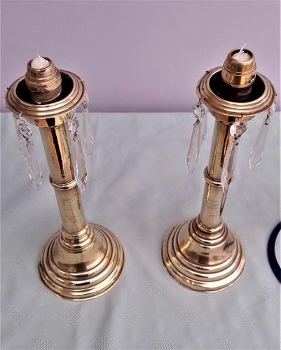 Pair of antique brass spring loaded hurricane candlesticks with grapevine etched glass shades with blue rim & cut glass prism lustre droppers 53 cm High 3.8 kg