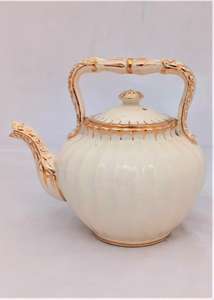 Antique creamware tea kettle shaped teapot with a ribbed  body and opulently gilded in a bachelor size circa 1870