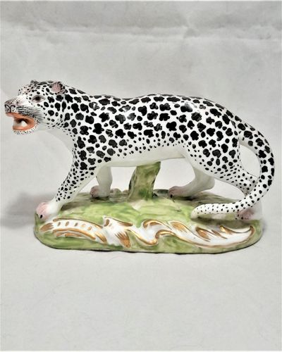 An antique 19th century porcelain Snow Leopard figurine realistically modelled and painted on a green and gilded enamel base probably French by Edme Samson circa 1890