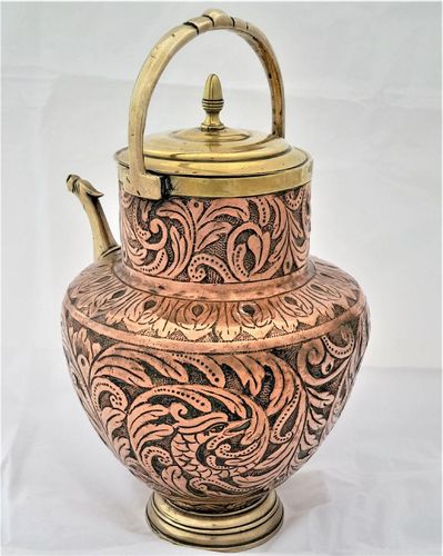 An antique Italian Tuscan repousse copper mezzina water carrier with brass fittings decorated with Cockatrice and acanthus leaf scrolls in an Arts and Crafts style circa 1900