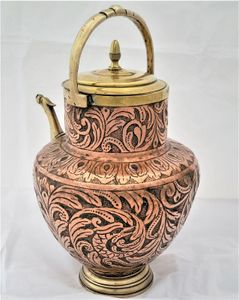 An antique Italian Tuscan repousse copper mezzina water carrier with brass fittings decorated with Cockatrice and acanthus leaf scrolls in an Arts and Crafts style circa 1900