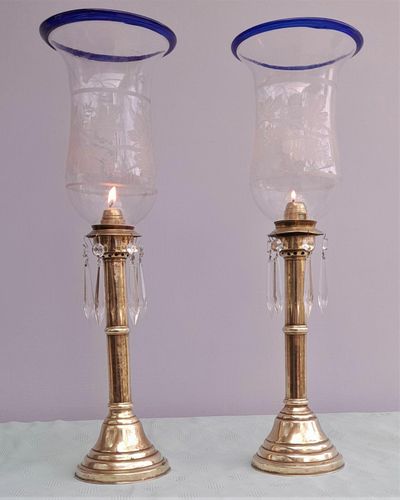 Pair of antique brass spring loaded hurricane candlesticks with grapevine etched glass shades with blue rim & cut glass prism lustre droppers 53 cm High 3.8 kg