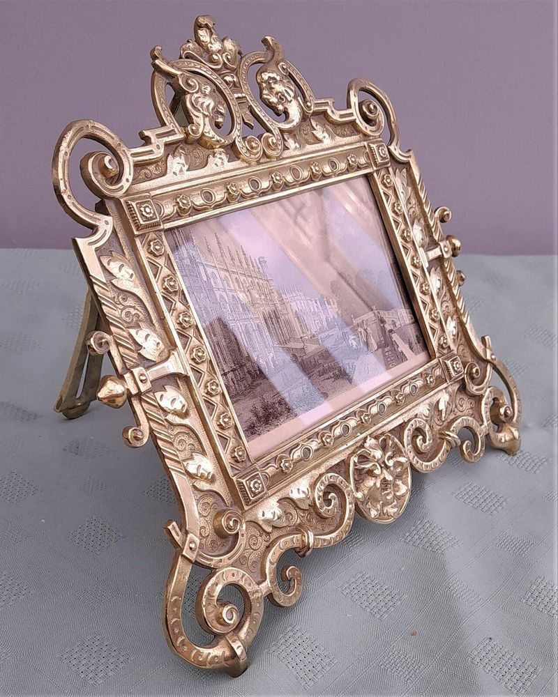 Antique Gothic Revival easel photo picture frame in high relief cast brass - decorated with helmeted leopards, the green man's head & ornate scrolls - for a landscape image size 6" x 4.5" - frame size 9" high, 10 inches wide by 8 inches deep, 19th century circa 1860. weighs 1156 grammes unpacked.