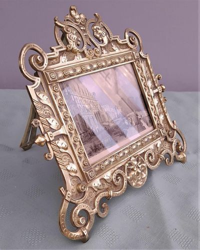 Antique Gothic Revival easel photo picture frame in high relief cast brass - decorated with helmeted leopards, the green man's head & ornate scrolls - for a landscape image size 6" x 4.5" - frame size 9" high, 10 inches wide by 8 inches deep, 19th century circa 1860. weighs 1156 grammes unpacked.