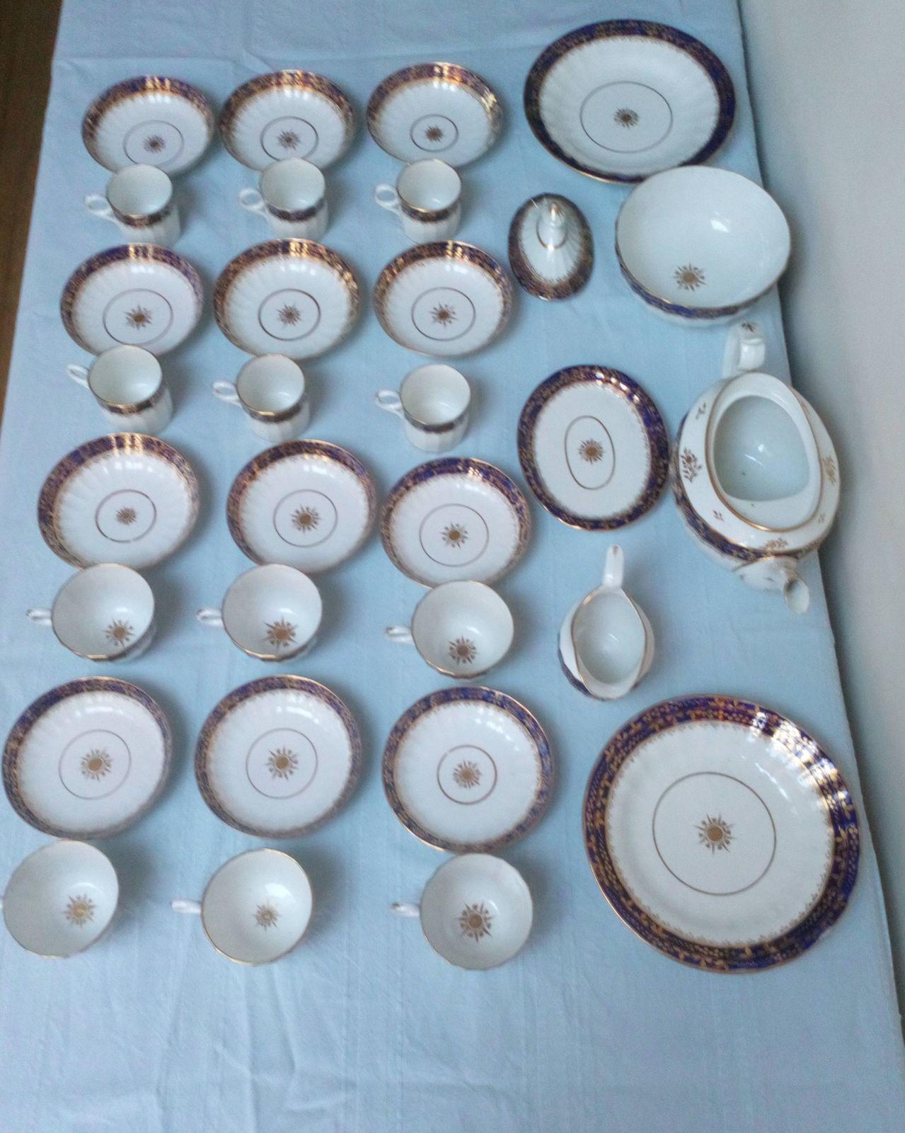 An antique Thomas Grainger Worcester Porcelain tea and coffee service with Hamilton Fluted Tea cups and coffee cans  and fluted new oval shaped teapot decorated with an under glaze blue band with gilded grapevines. Pattern number 195 circa 1810