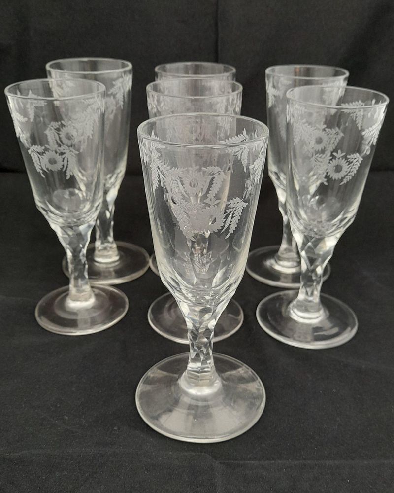 Antique set of seven Georgian style tall round funnel bowl flutes on diamond faceted stems and plain feet. The bowls wheel engraved with OXO and floral swags. Antique Ale Glasses or Champagne Flutes circa 1890