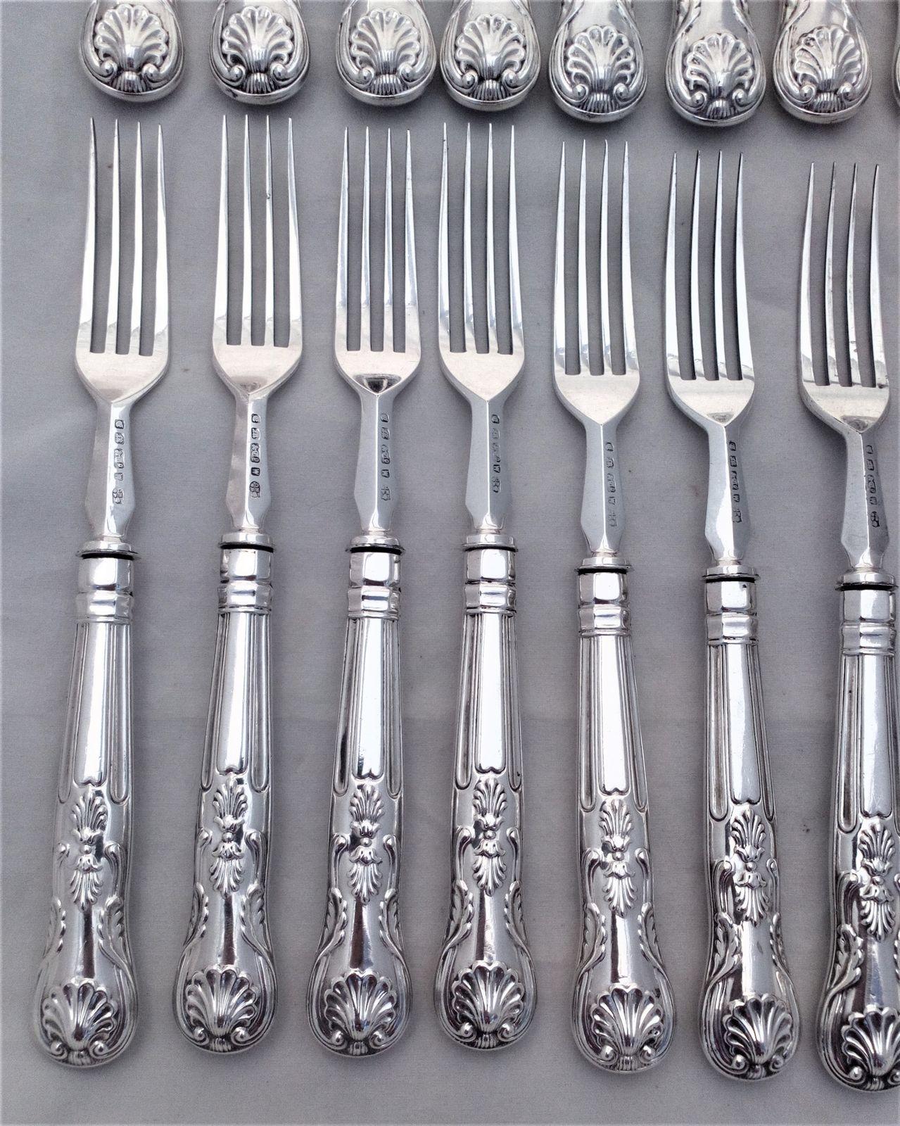 An antique set of twelve place setting of Elkington silver plated cutlery with Kings pattern handles. The round nosed bladed knives and the four pronged forks are each marked with the Elkington and Co marks and the date code W for 1882.