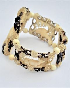 A superb antique hand carved deer antler elasticated panel bracelet with exquisite detail and brown enamel highlighting. The main panels are decorated with deer, the large one with a hart or stag and the sides with seated does. The bracelet dates from the middle of the 19th century in the Victorian period circa 1850. Probably carved in the Black Forest region.