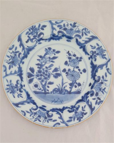 An antique Chinese export porcelain dinner plate hand painted in blue and white with a hollow blue rock peony and chrysanthemum pattern Kangxi period Qing dynasty early 18th Century