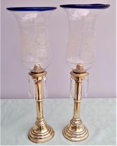 Pair of antique brass spring loaded hurricane candlesticks with grapevine etched glass shades with blue rim & cut glass prism lustre droppers 53 cm High 3.8 kg