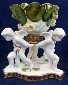 An antique porcelain Moore Brothers winged cherub or putto water lily decorated table centrepiece retailed by Thomas Goode and co circa 1880.