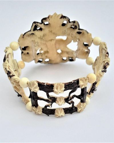 A superb antique hand carved deer antler elasticated panel bracelet with exquisite detail and brown enamel highlighting. The main panels are decorated with deer, the large one with a hart or stag and the sides with seated does. The bracelet dates from the middle of the 19th century in the Victorian period circa 1850. Probably carved in the Black Forest region.