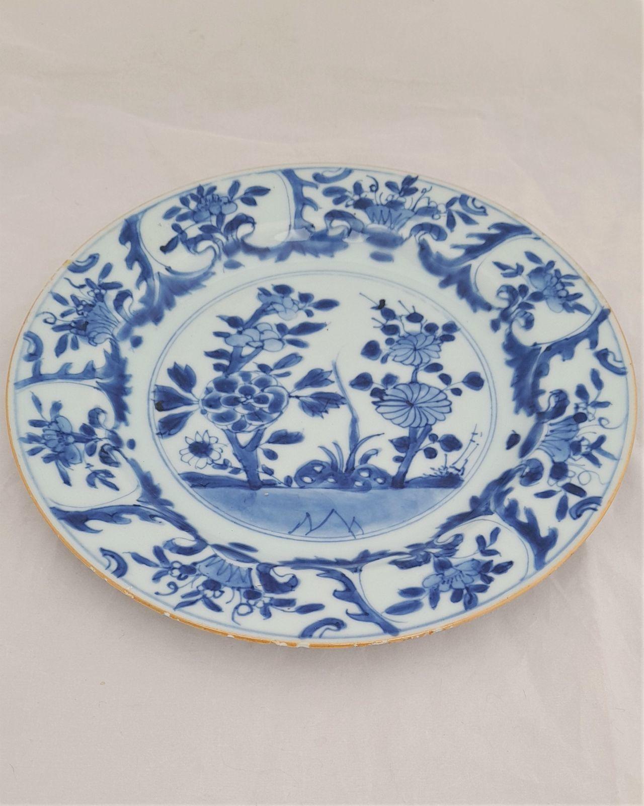An antique Chinese export porcelain dinner plate hand painted in blue and white with a hollow blue rock peony and chrysanthemum pattern Kangxi period Qing dynasty early 18th Century