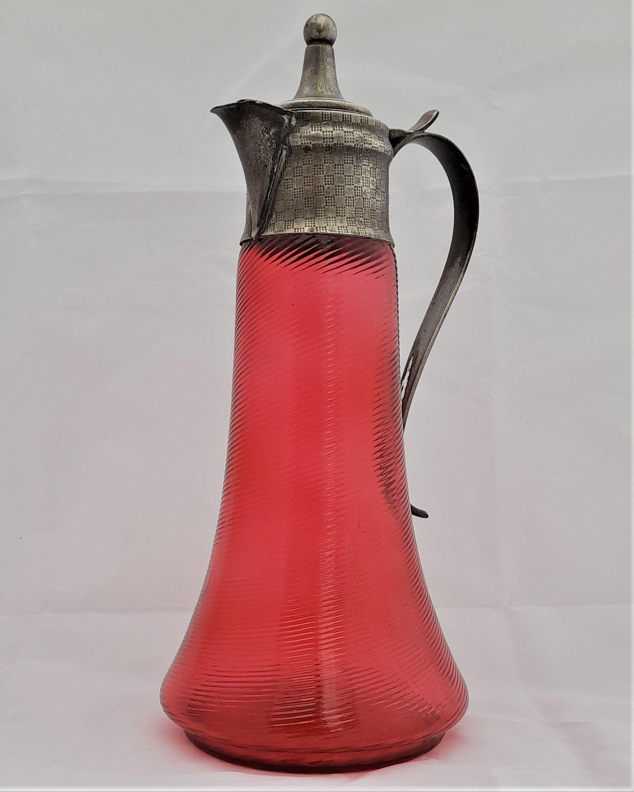 Antique Art Nouveau swirl threaded ruby glass or cranberry glass claret jug with embossed silver plated mounts circa 1900 1 litre capacity.