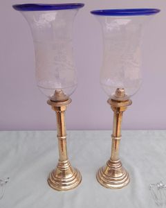 Pair of antique brass spring loaded hurricane candlesticks with grapevine etched glass shades with blue rim & cut glass prism lustre droppers 53 cm High 3.8 kg