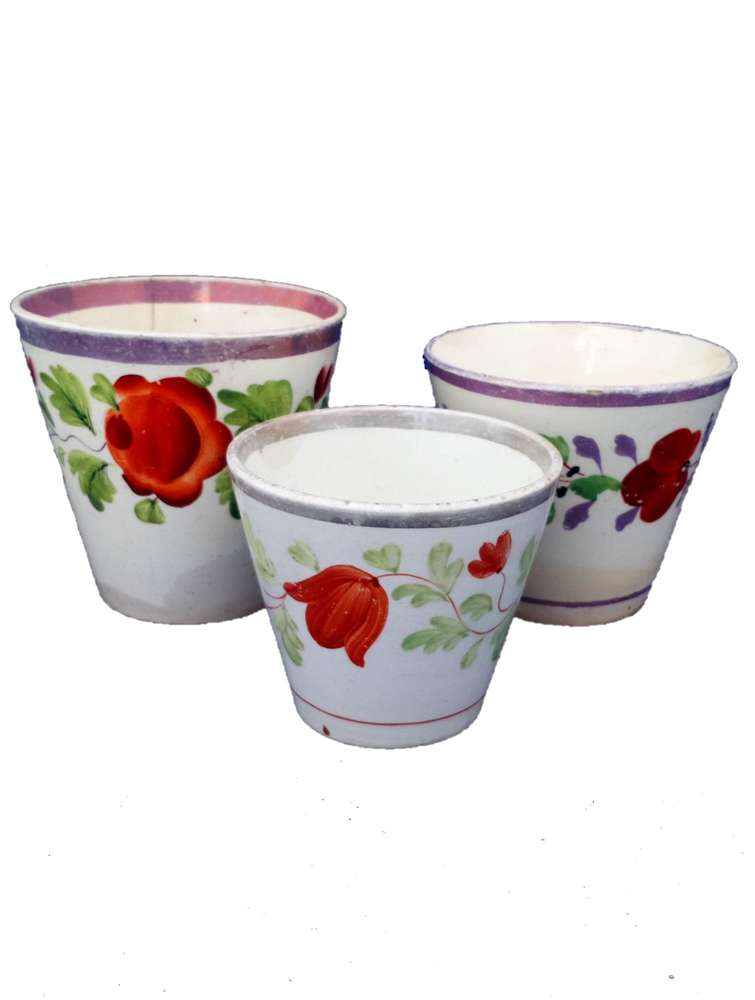 Three antique graduated pearlware and creamware pottery pink lustre ale beakers or cups with hand painted flowers circa 1820