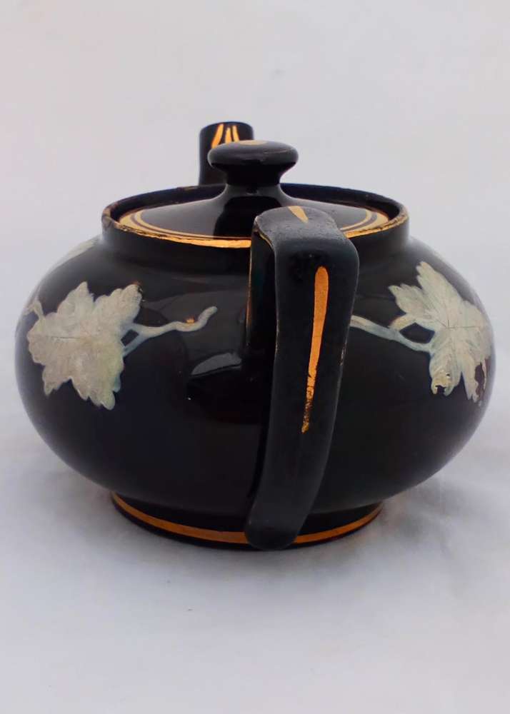 Victorian black glazed teapot with white enamelled vine leaves and stems antique circa 1850
