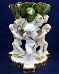 An antique porcelain Moore Brothers winged cherub or putto water lily decorated table centrepiece retailed by Thomas Goode and co circa 1880.
