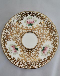 An antique mid Victorian porcelain tea cup and saucer with a scalloped rim and reinforced handle hand painted with roses and gilded extensively with a sea weed pattern made by Sir James Duke & Nephews circa 1860 in the factory previously run by Samuel Alcock and company.