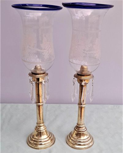 Pair of antique brass spring loaded hurricane candlesticks with grapevine etched glass shades with blue rim & cut glass prism lustre droppers 53 cm High 3.8 kg