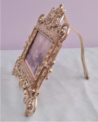 Antique Gothic Revival easel photo picture frame in high relief cast brass - decorated with helmeted leopards, the green man's head & ornate scrolls - for a landscape image size 6" x 4.5" - frame size 9" high, 10 inches wide by 8 inches deep, 19th century circa 1860. weighs 1156 grammes unpacked.