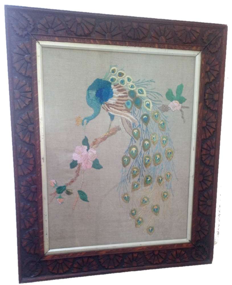 Antique Arts and Crafts Peacock silk long stitch embroidery on unbleached linen in a thistle and daisy carved oak wooden frame